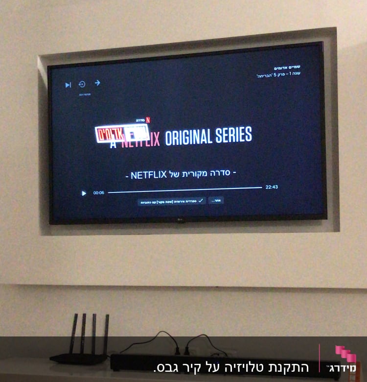 טלוויזיה תלויה על הקיר עם נתב ומזגן